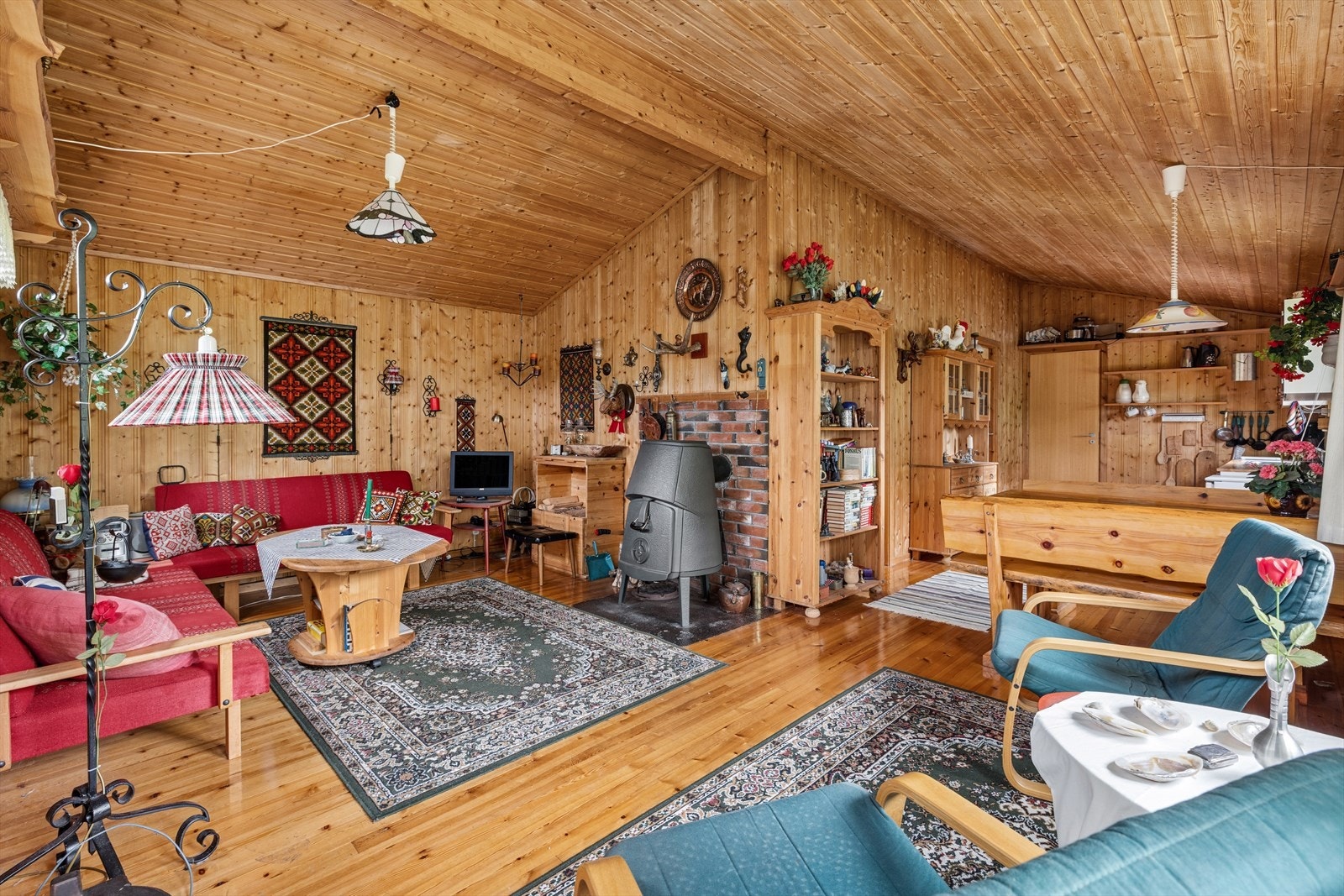 Hytta varmes opp med en eldre vedovn, og har panel på vegger og i tak. Galleribilde