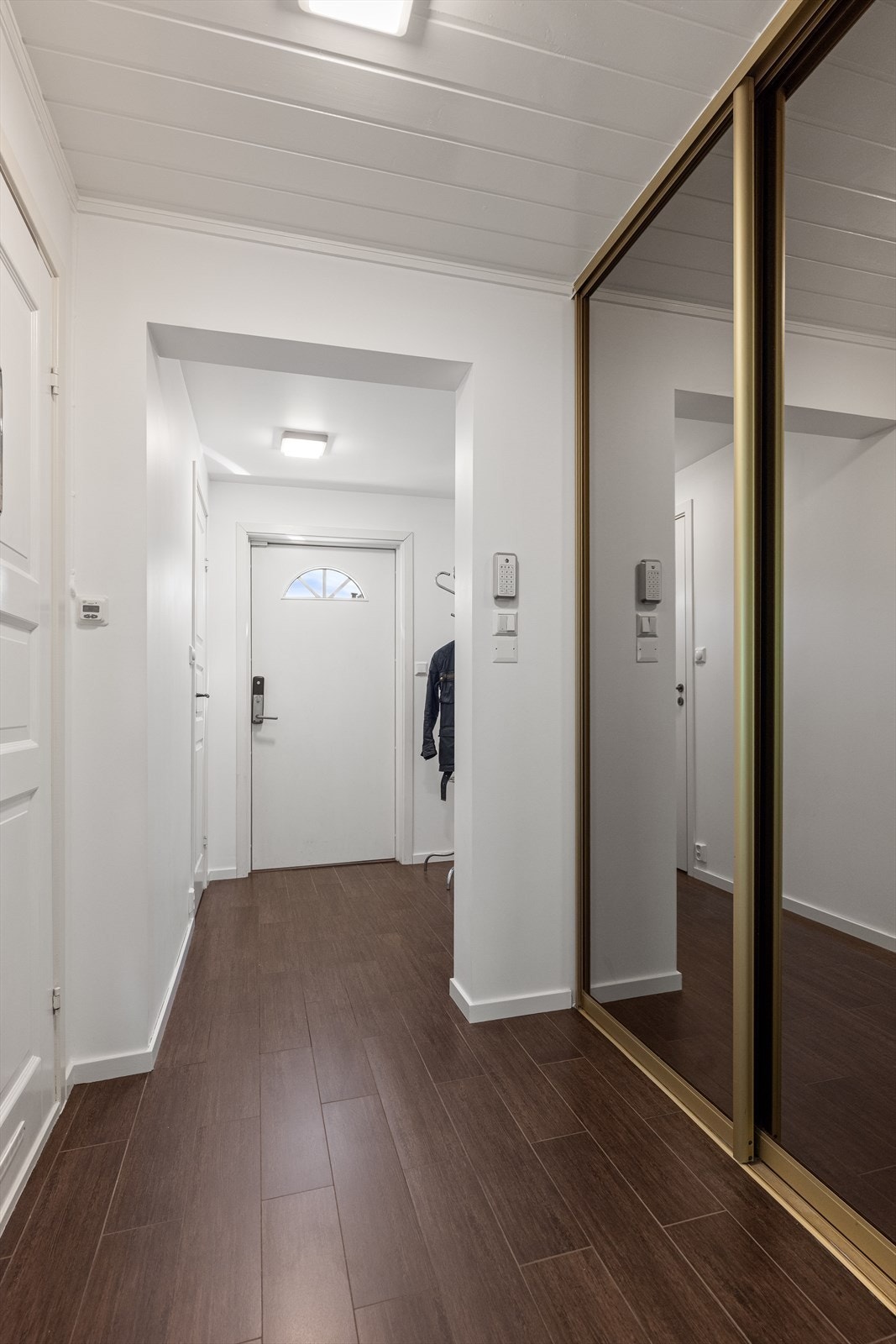 Videre inn i gangen finner du en romslig skyvedørsgarderobe med speilfronter, som gir ytterligere oppbevaringsmuligheter. Galleribilde