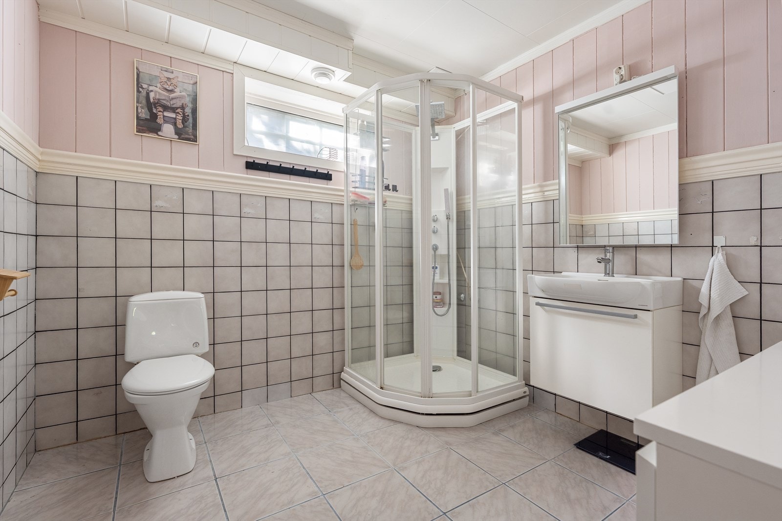 Innredet utleieenhet - Badet er innredet med servantskap med nedfelt servant, speil med belysning over, veggskap, gulvmontert toalett og dusjkabinett. Galleribilde