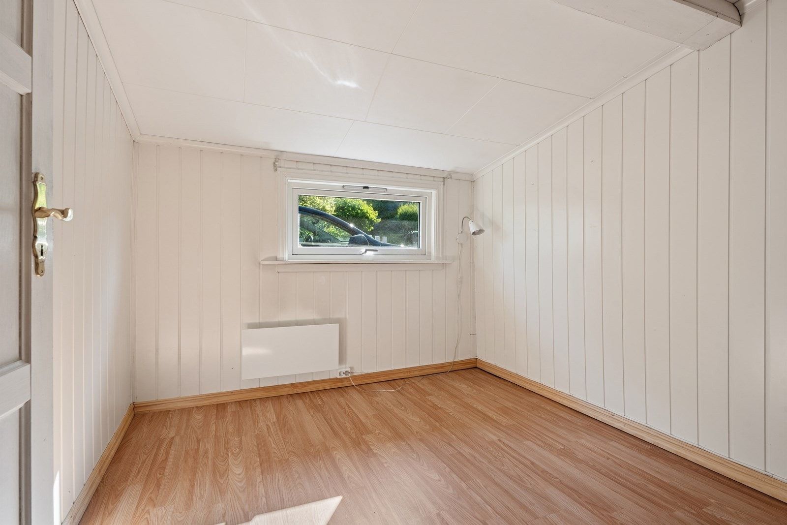 Det andre soverommet har laminatgulv og vegger med malt panel. Galleribilde