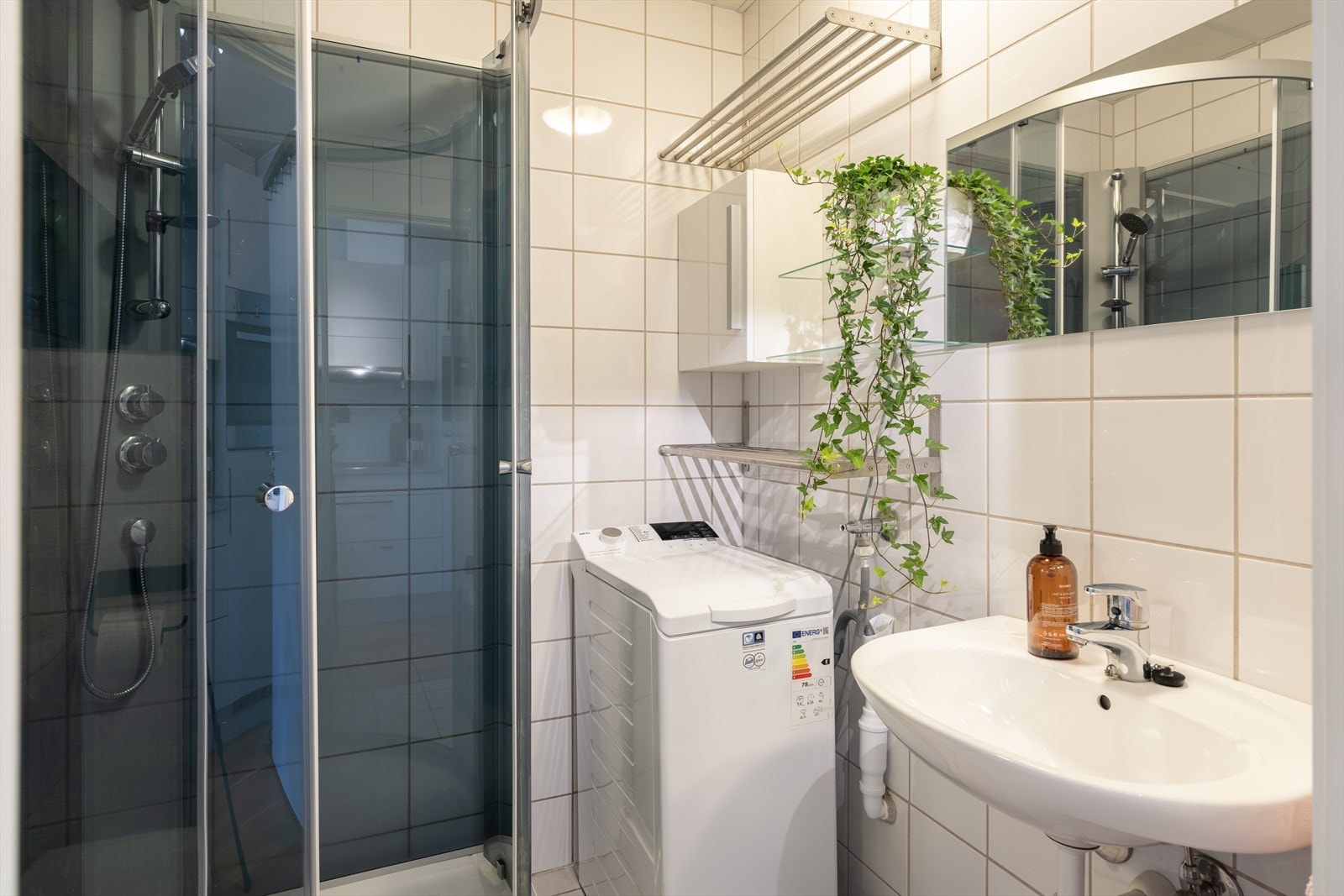 Lyst og flislagt bad på 2,5 m², med opplegg for vaskemaskin, smarte oppbevaringsløsninger og behagelig gulvvarme. Galleribilde