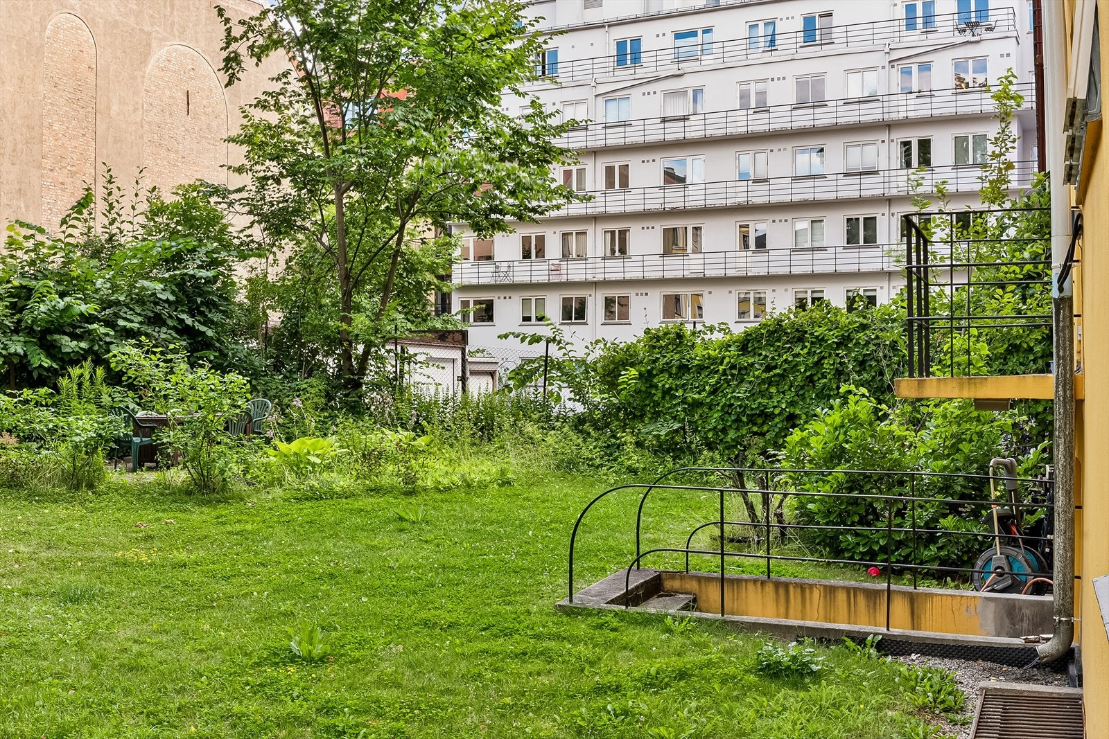 Pent opparbeidet fellestomt med plen og diverse beplantning Galleribilde