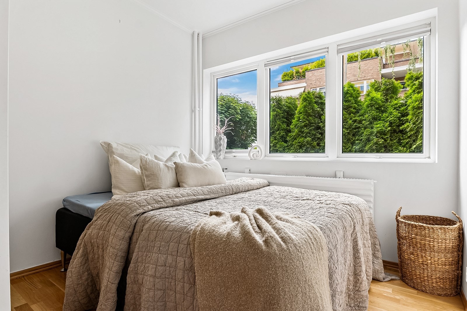 Lyst og delikat soverom med store vindusflater som slipper inn rikelig med naturlig lys. Soverommet vender ut mot en rolig og frodig bakgård Galleribilde