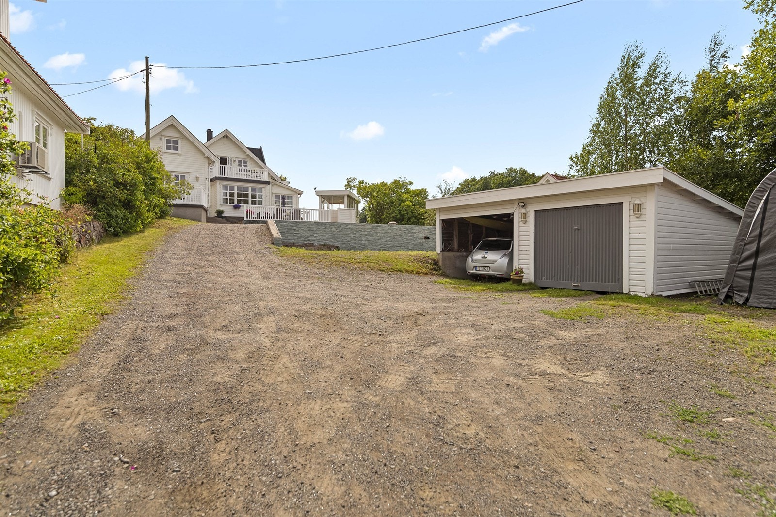 Garasje med tilhørende carport, samt god plass til parkering på tomten. Galleribilde