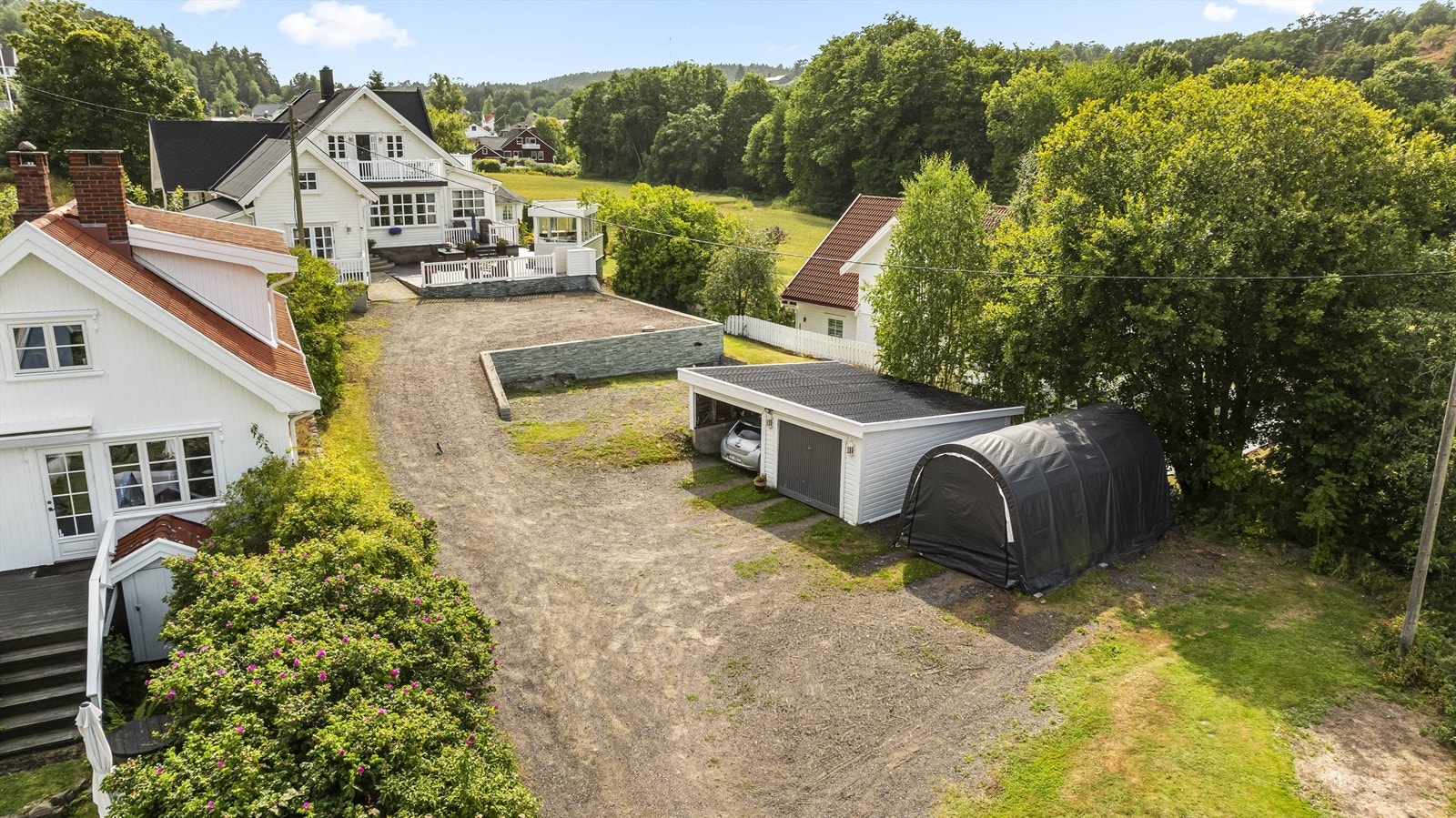 Romslig gårdsplass med adkomst til både hovedhus og sidebygning. Galleribilde