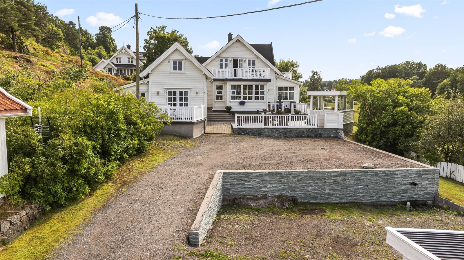 Forstøtningsmur med stein rammer inn deler av uteområdet. Galleribilde