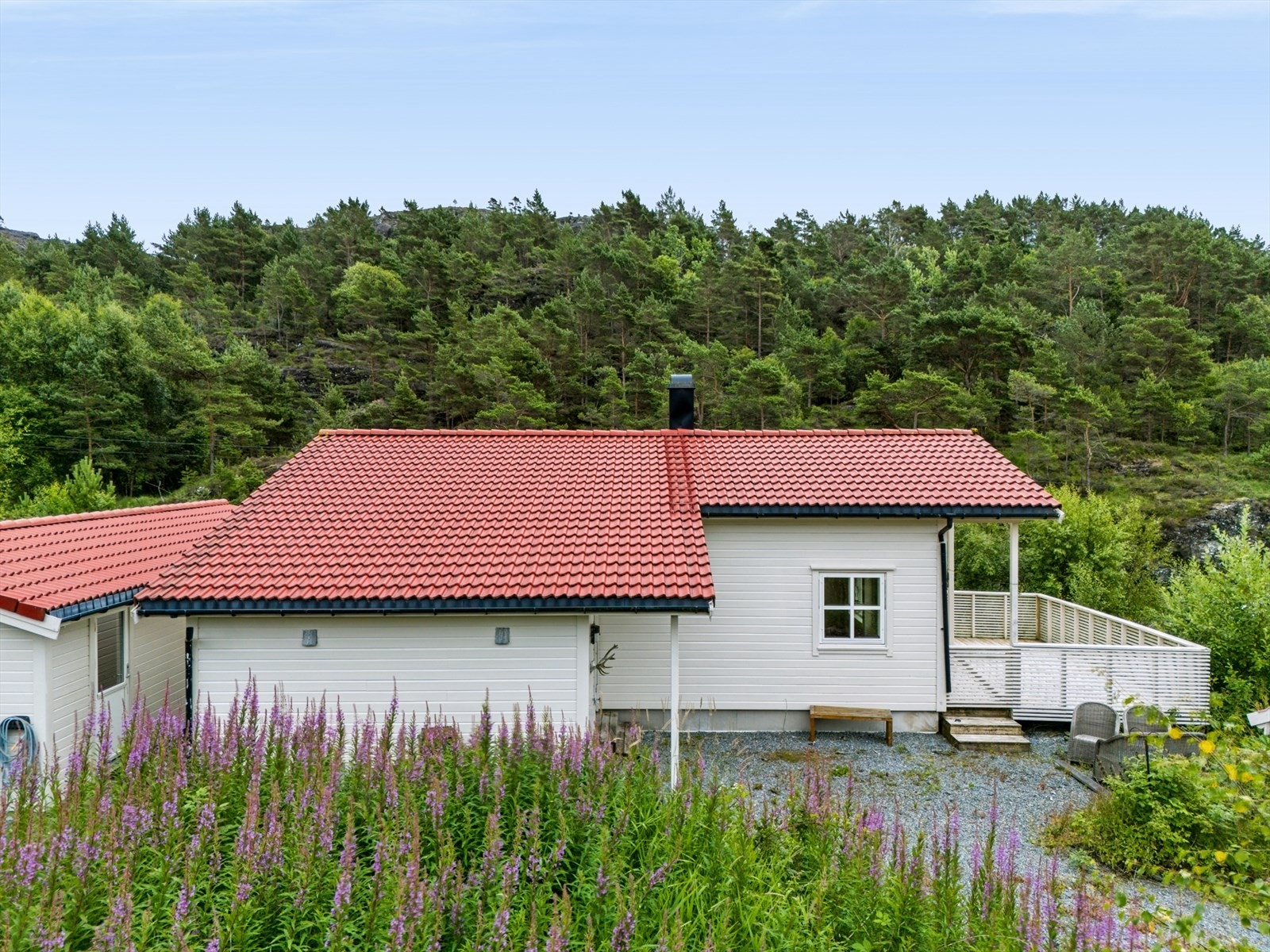 Enebolig og garasje med utvendig liggende trekledning og tak med betongtakstein. Galleribilde