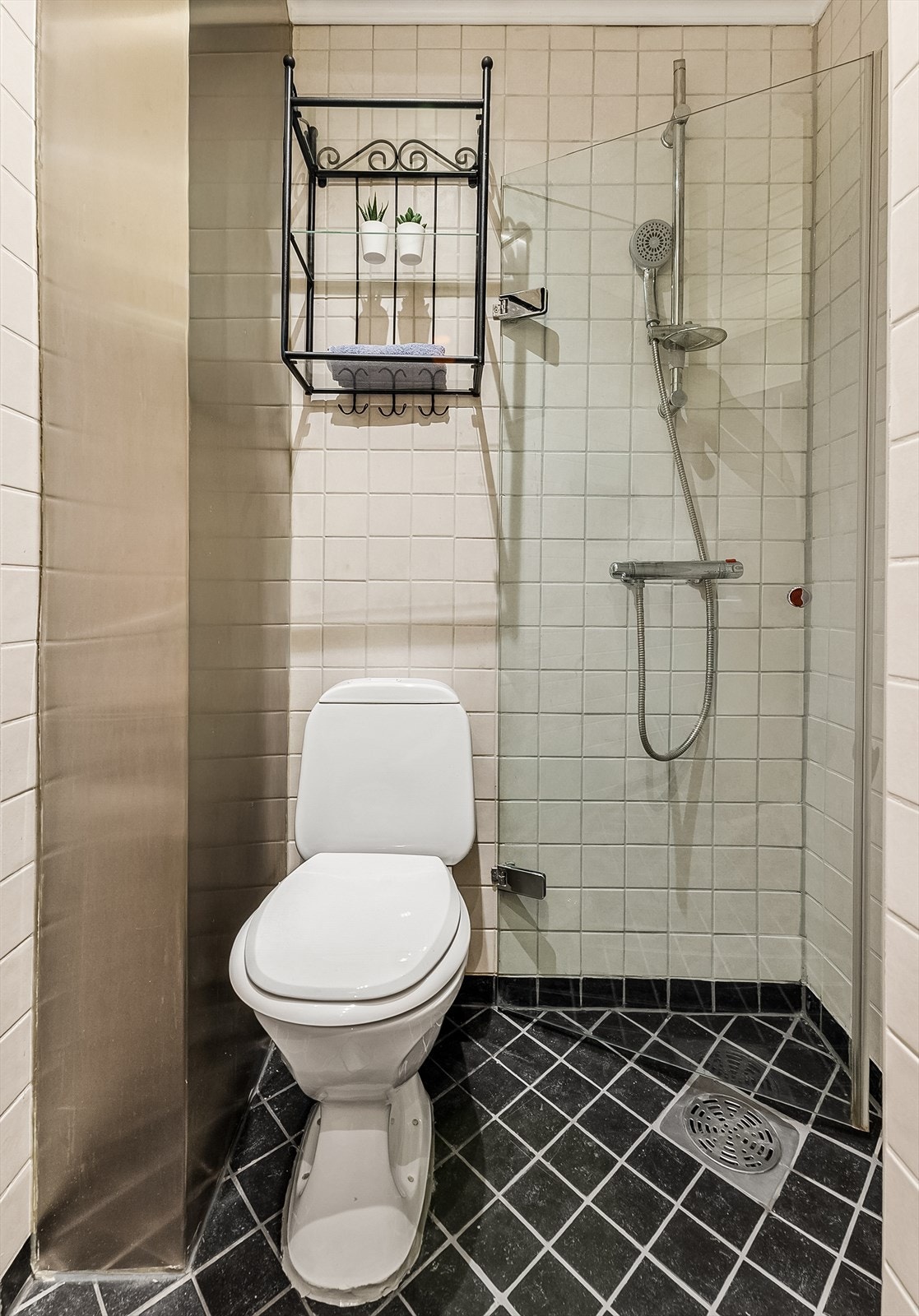Baderommet er utstyrt med åpen dusj, innfellbar dusjdør, naturlig avtrekk, servant, servantskap og wc Galleribilde