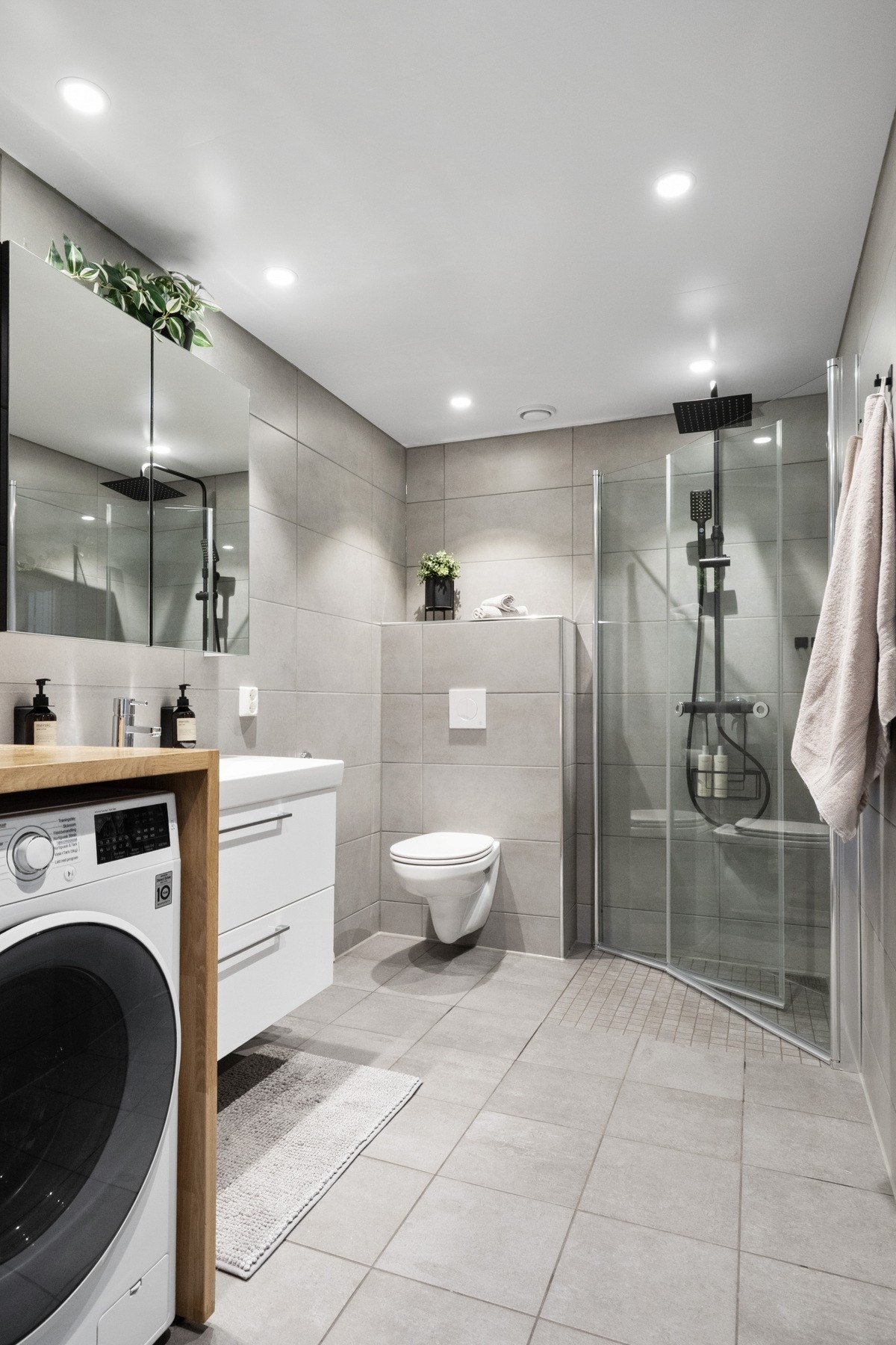 Badet er delikat med lysegrå fliser på gulv og vegger, gulvvarme og downlights. Galleribilde