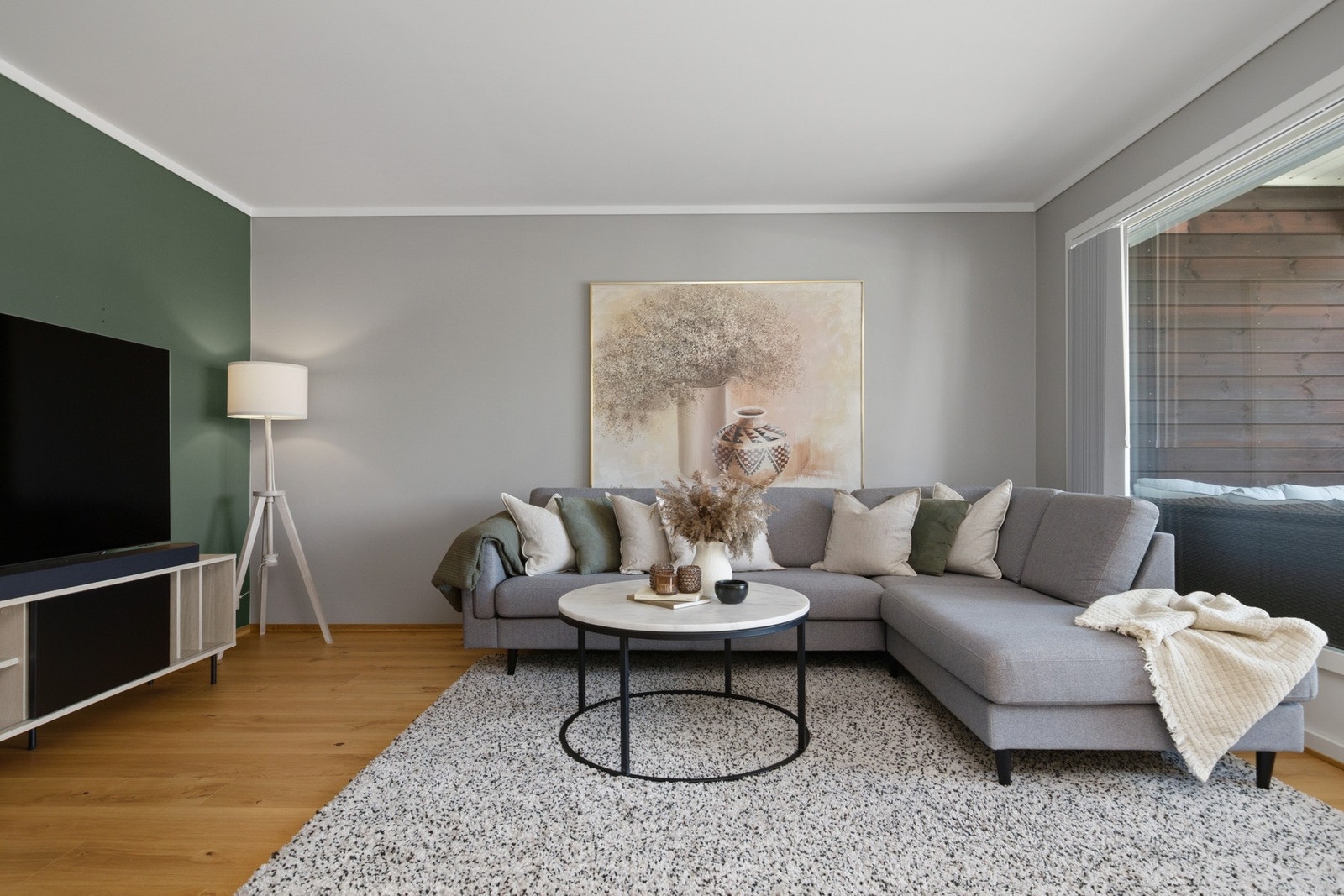 Stuen har pent parkettgulv i enstavs design, glatte, gråmalte veggflater, grønn fondvegg og hvitmalt, glatt himling. Galleribilde