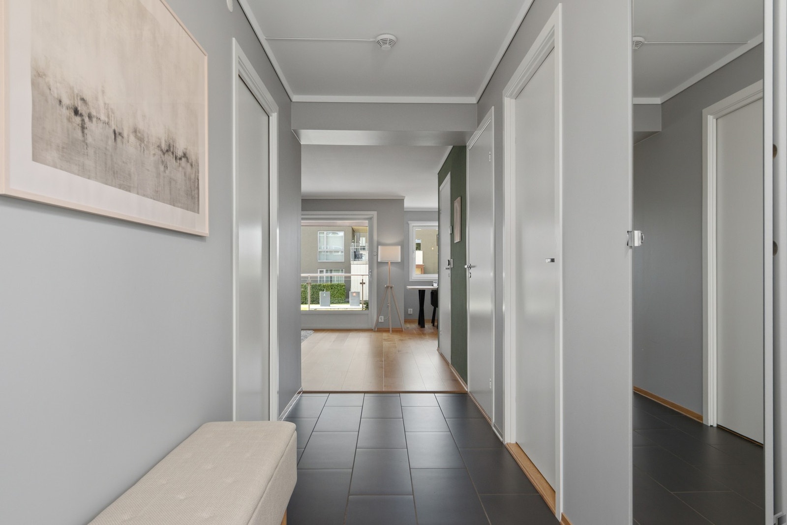 Rommet ligger åpent mot stuen og er innredet med skyvedørsgarderobe som har hvite fronter og speil. Galleribilde