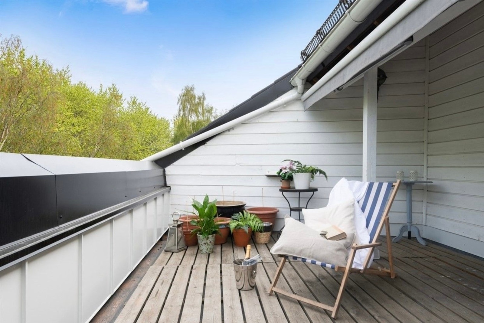 Romslig terrasse med plass til både sittegruppe og grønne innslag, vendt mot rolige og frodige omgivelser. Galleribilde