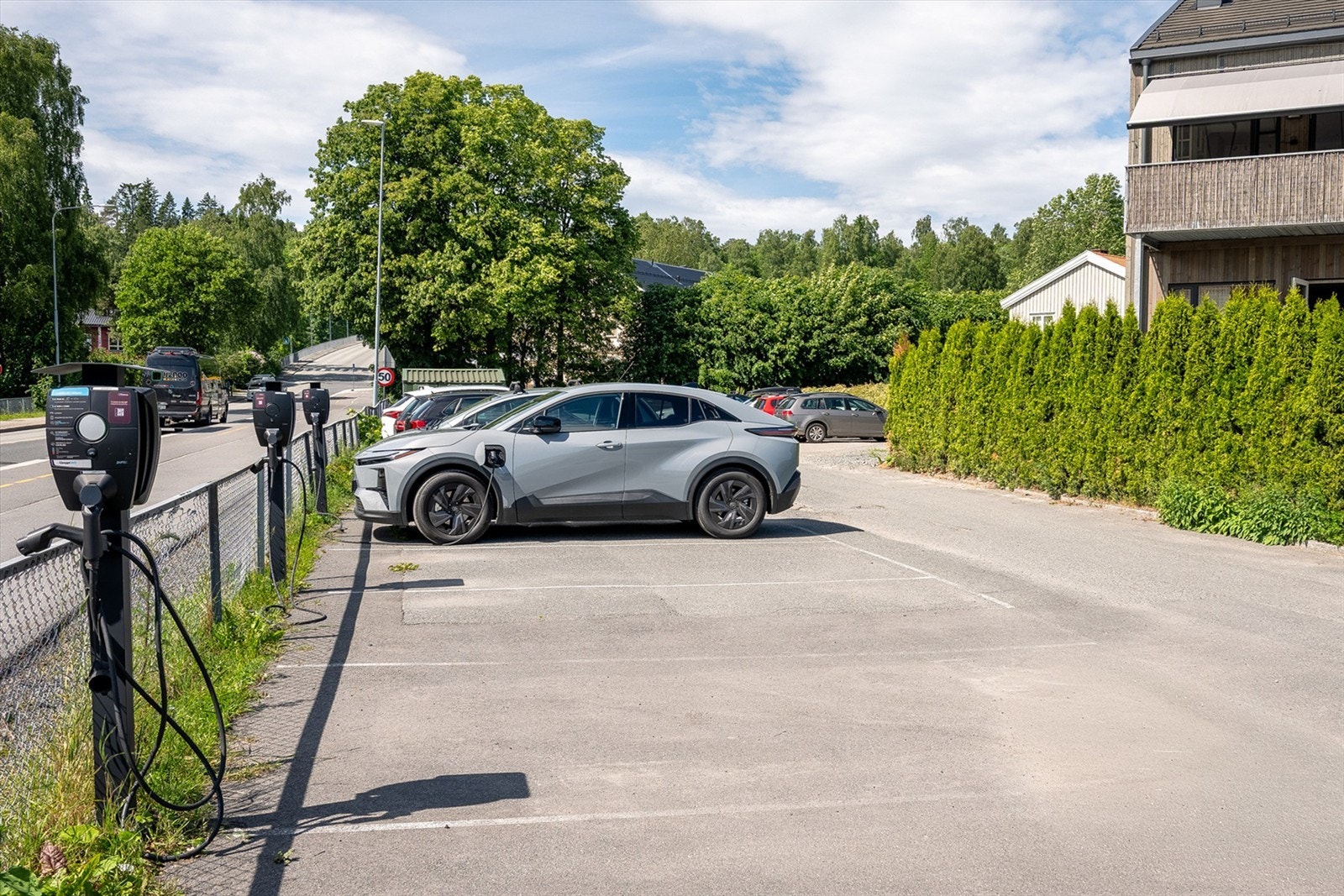 Selger opplyser om felles parkeringsplasser som er tilgjengelige for beboerne med ofte ledige plasser. Det er el-bil lader på felles parkeringsplass Galleribilde
