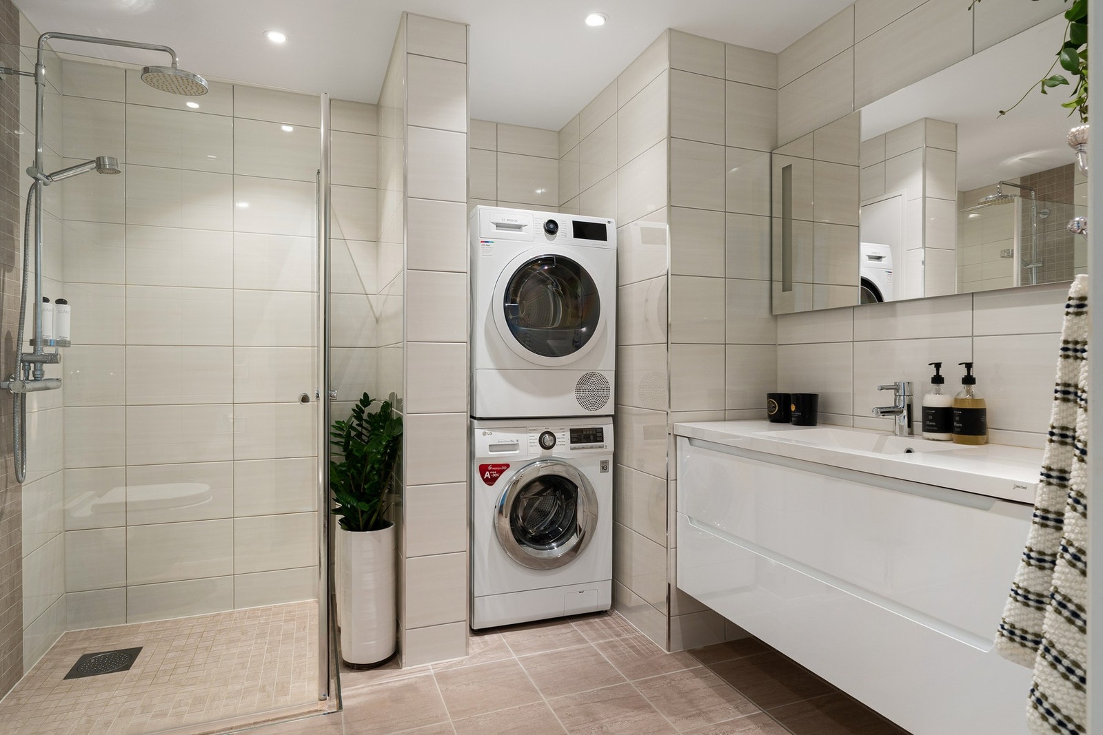 Moderne og delikat bad på hele ca. 6,5 kvm. Badet har en romslig regnfallsdusj og opplegg for vaskemaskin og tørketrommel. Galleribilde