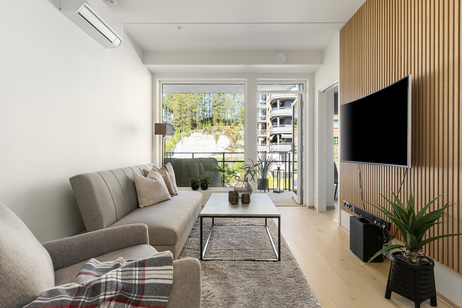 Stuen har lyse overflater og store vinduer som slipper lyset inn. Det er montert airconditon i stuen Galleribilde