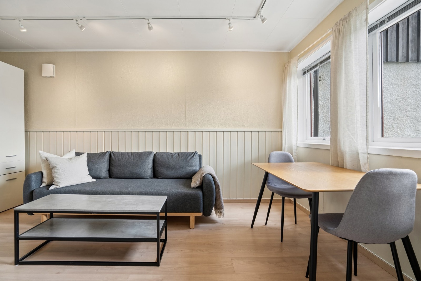 Vegger i stuen har en kombinasjon av malte flater og brystningspanel. Galleribilde