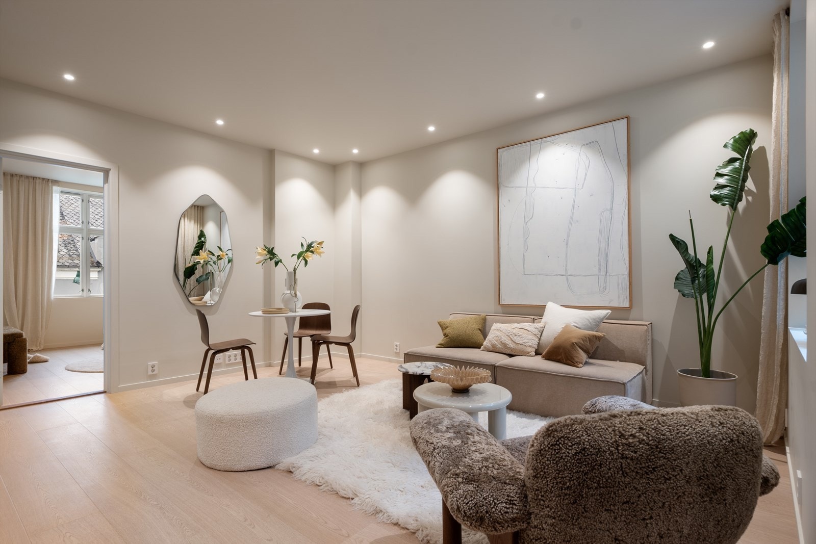 Innfelte LED-spotter i taket, plassert langs ytterkanten som en elegant ramme rundt rommet. Galleribilde