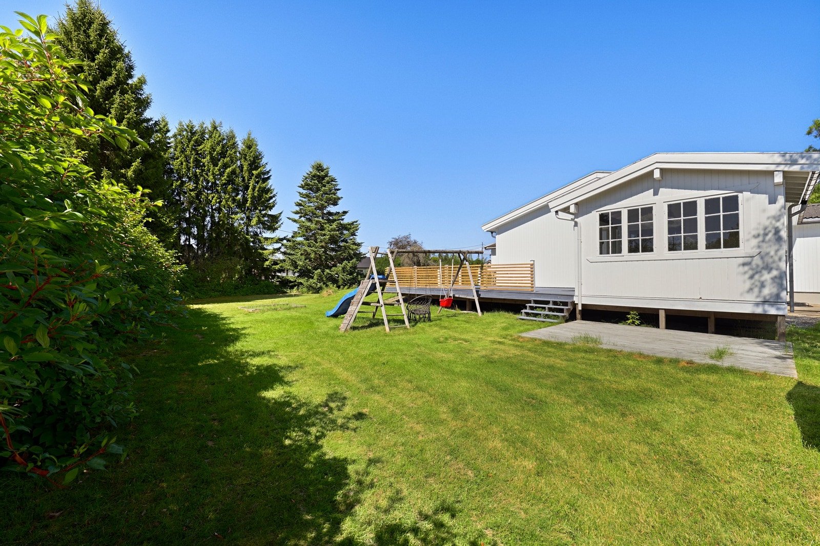 I den store hagen er det en liten markterrasse, en koselig lekestue, en sandkasse og et huskestativ. Galleribilde