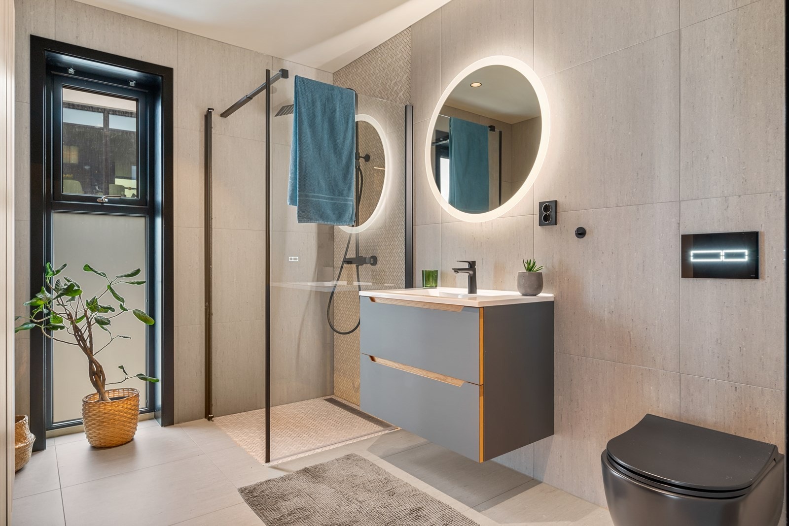 Badet i 1. etasje er stilfullt innredet med regnfallsdusj, varmekabler og store, delikate fliser. Galleribilde