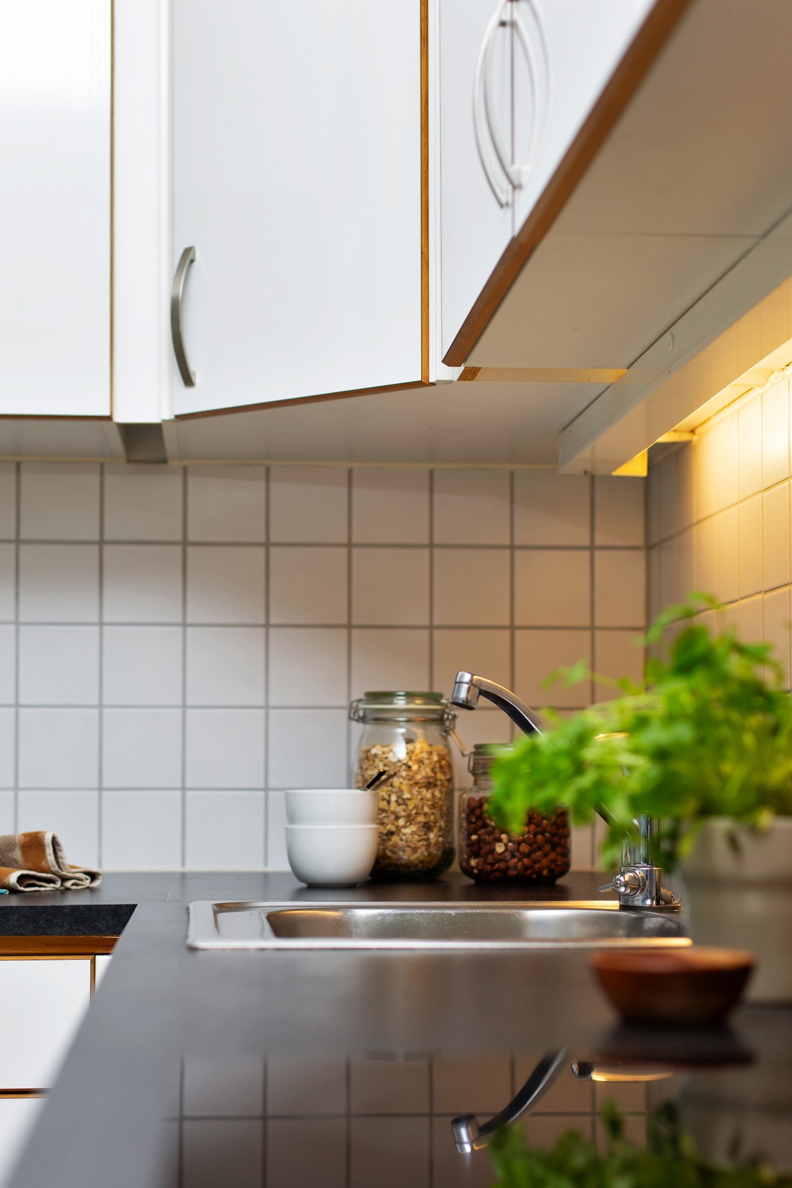 Kjøkkeninnredningen har slette fronter og over benkeplaten i laminat er det flislagt for en praktisk og lettstelt løsning. Galleribilde