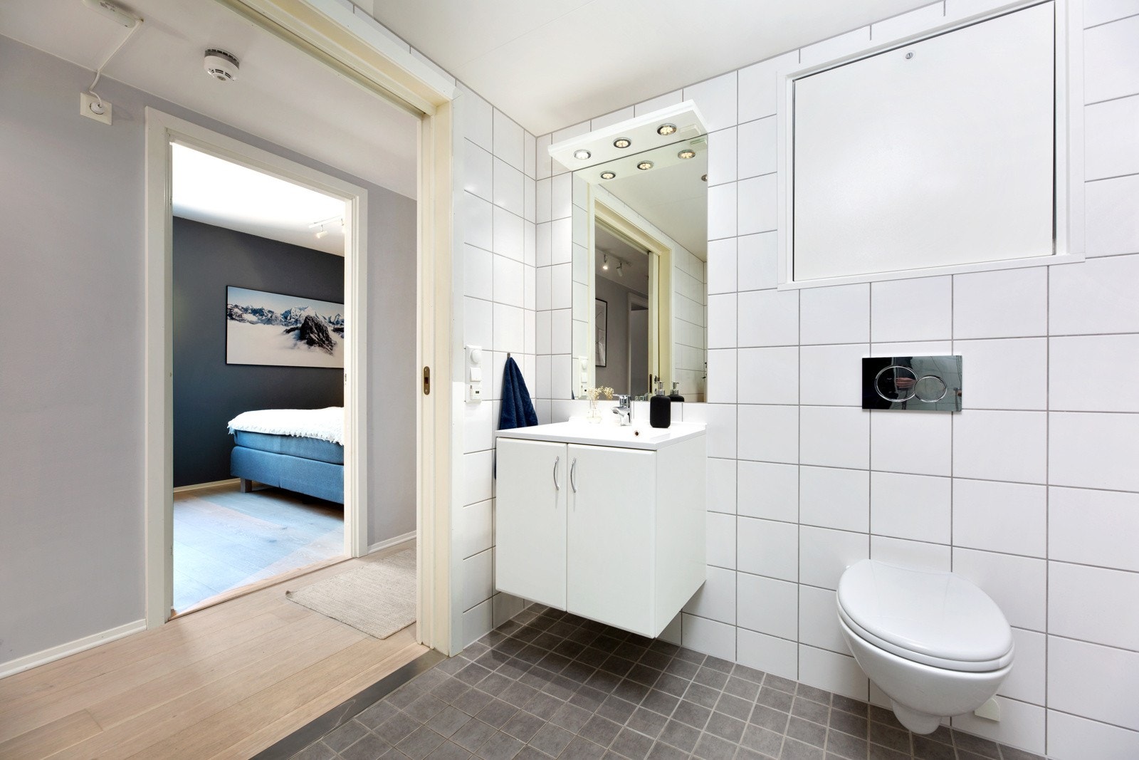 Badet har vegghengt servantskap med ovenpåliggende servant og innfelt speil med belysning. Galleribilde