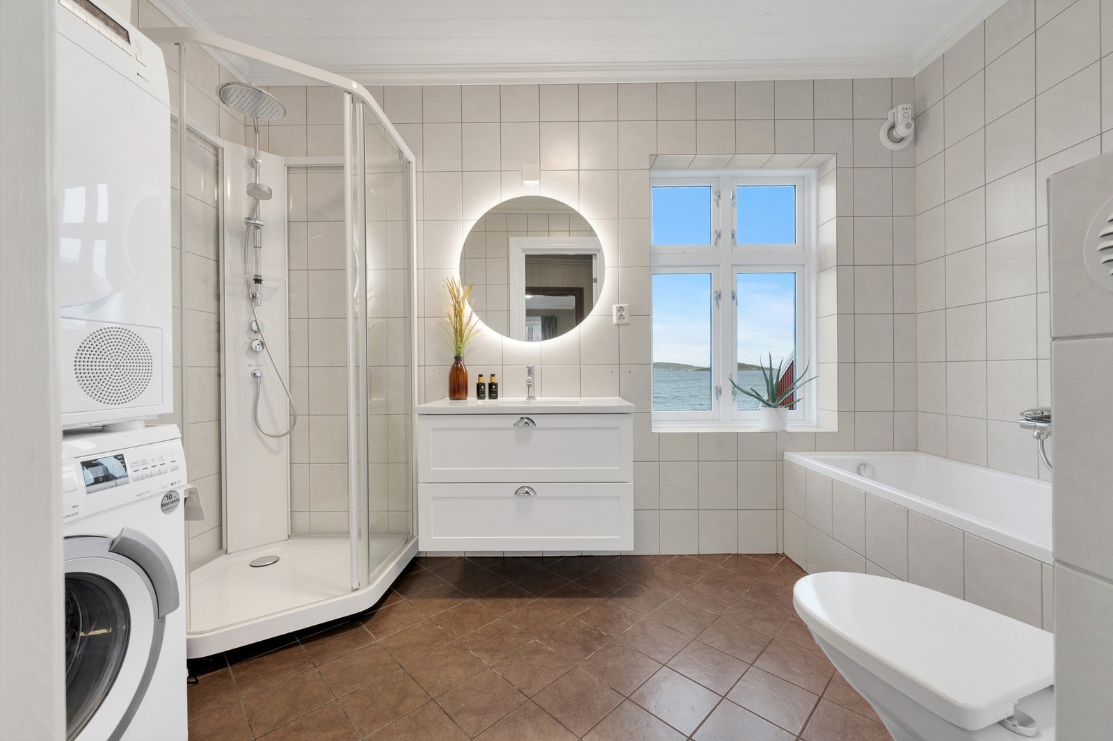 Badet har keramiske fliser, gulvvarme og opplegg for vaskemaskin. Galleribilde