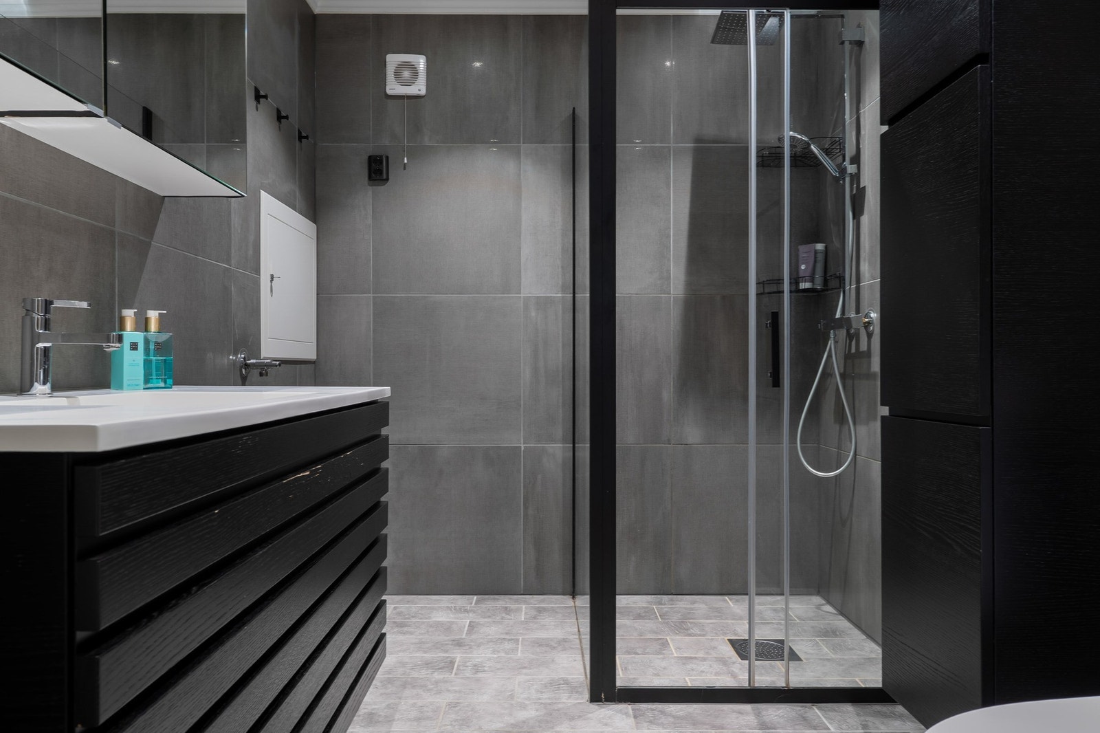 Badet er utstyrt med servantinnredning med speilskap, toalett og dusj med glassvegger. Galleribilde