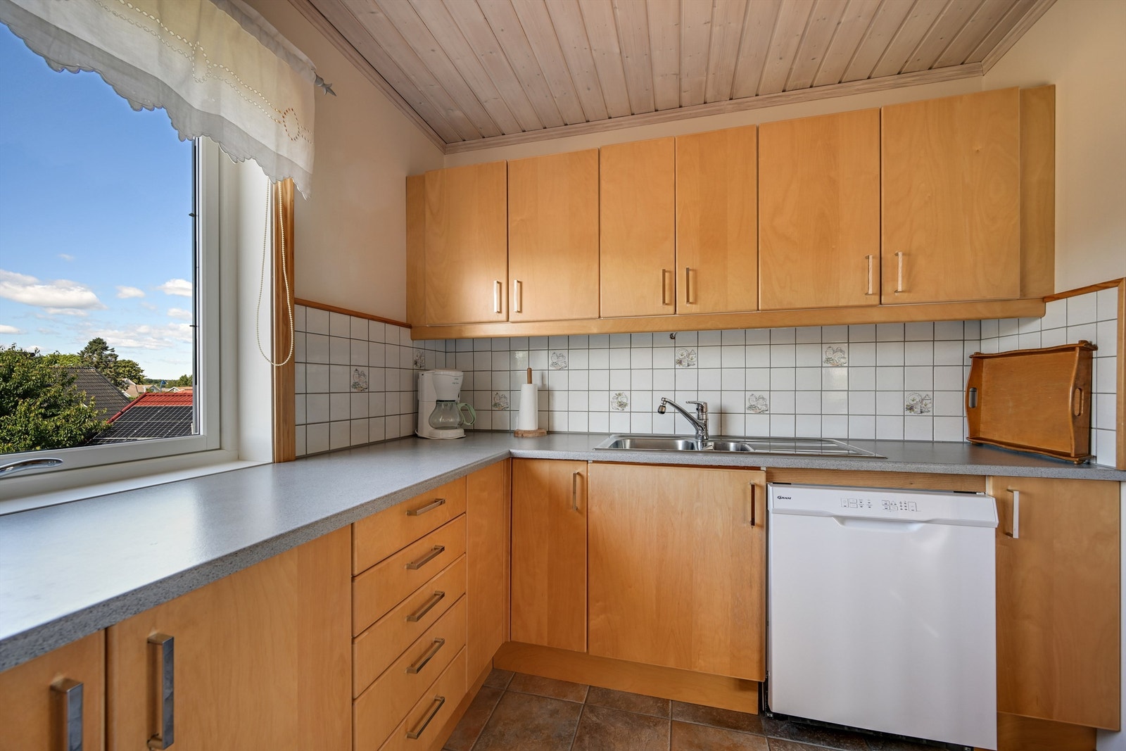 Benkeplaten er i laminat, og det er tilrettelagt med nisjer for kjøl-/fryseskap, oppvaskmaskin og stekeovn. Galleribilde