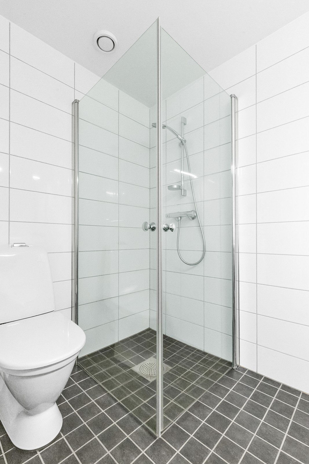 Flislagt bad med dusjhjørne med innfellbare glassdører for optimal plassutnyttelse. Galleribilde