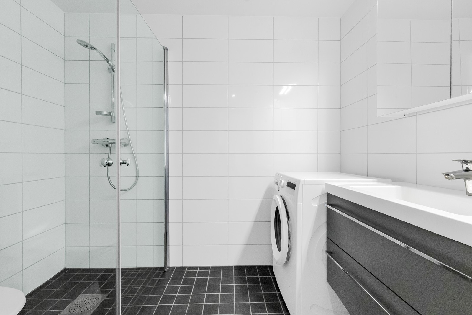 Badet har gulvvarme, servantinnredning og opplegg for vaskemaskin Galleribilde