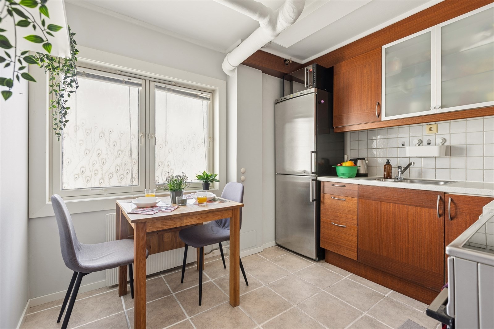 Kjøkkenet har en egen spiseplass ved vinduet, flislagt gulv og radiator for vannbåren varme. Galleribilde