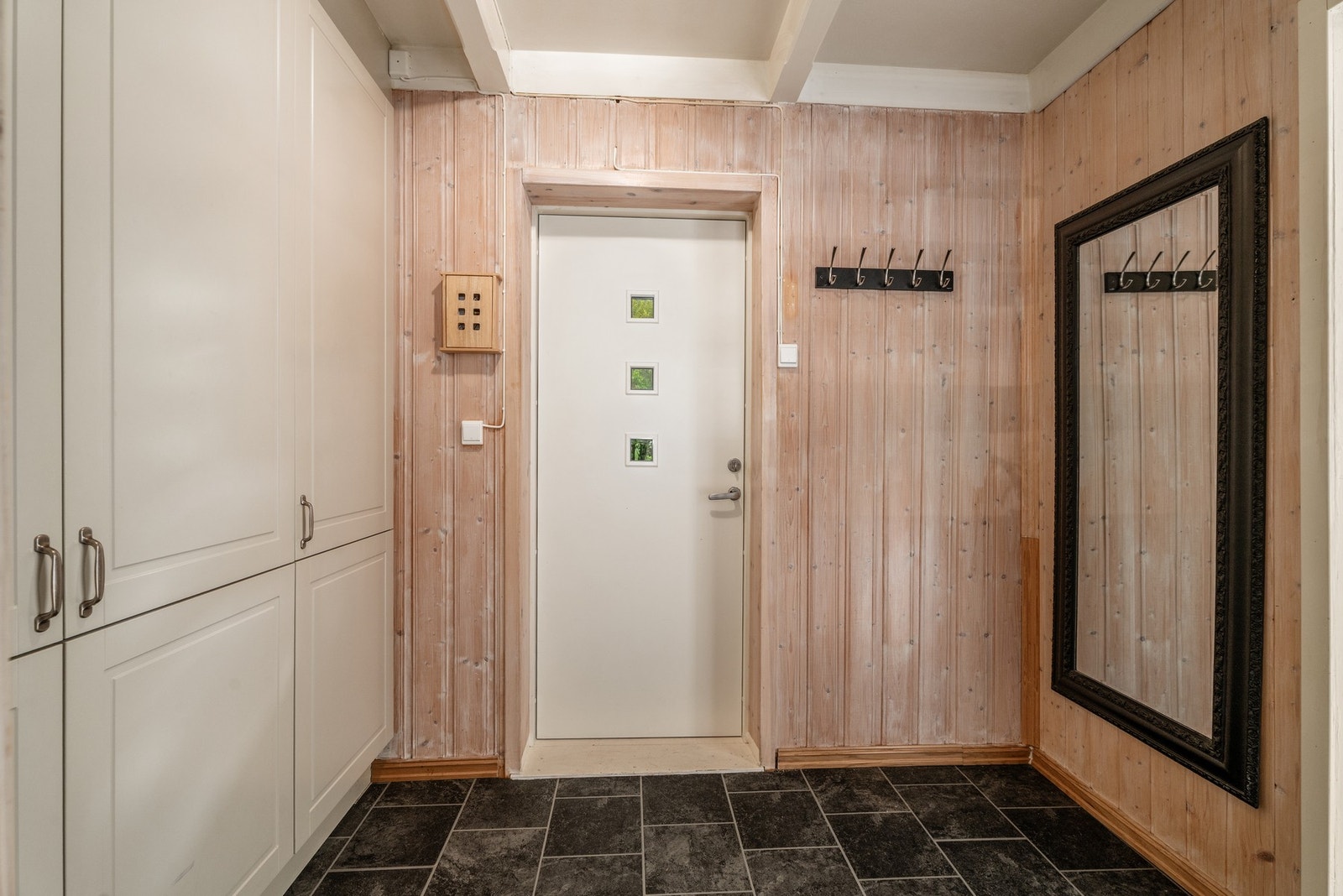 Inngangsdør på sørsiden og en entré som har plass til garderobe. Galleribilde