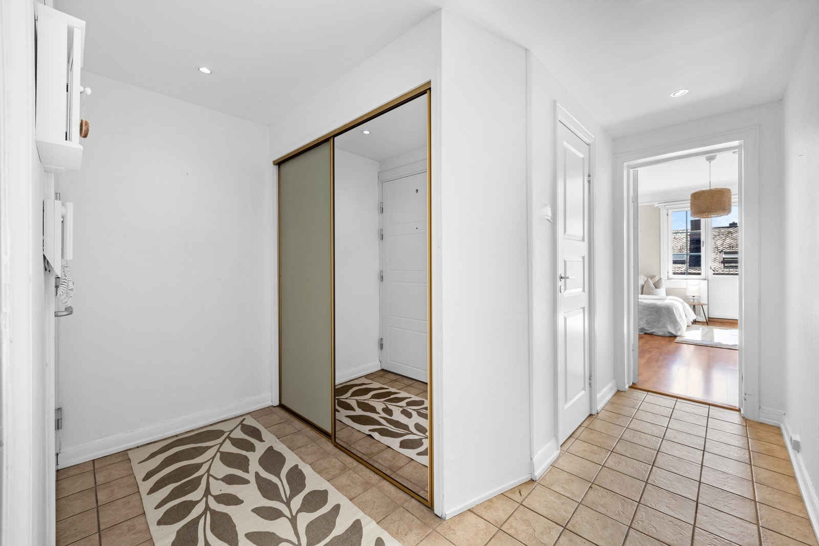 Velkommen inn! Praktisk entré med flislagt gulv og skyvedørsgarderobe oppbevaring Galleribilde