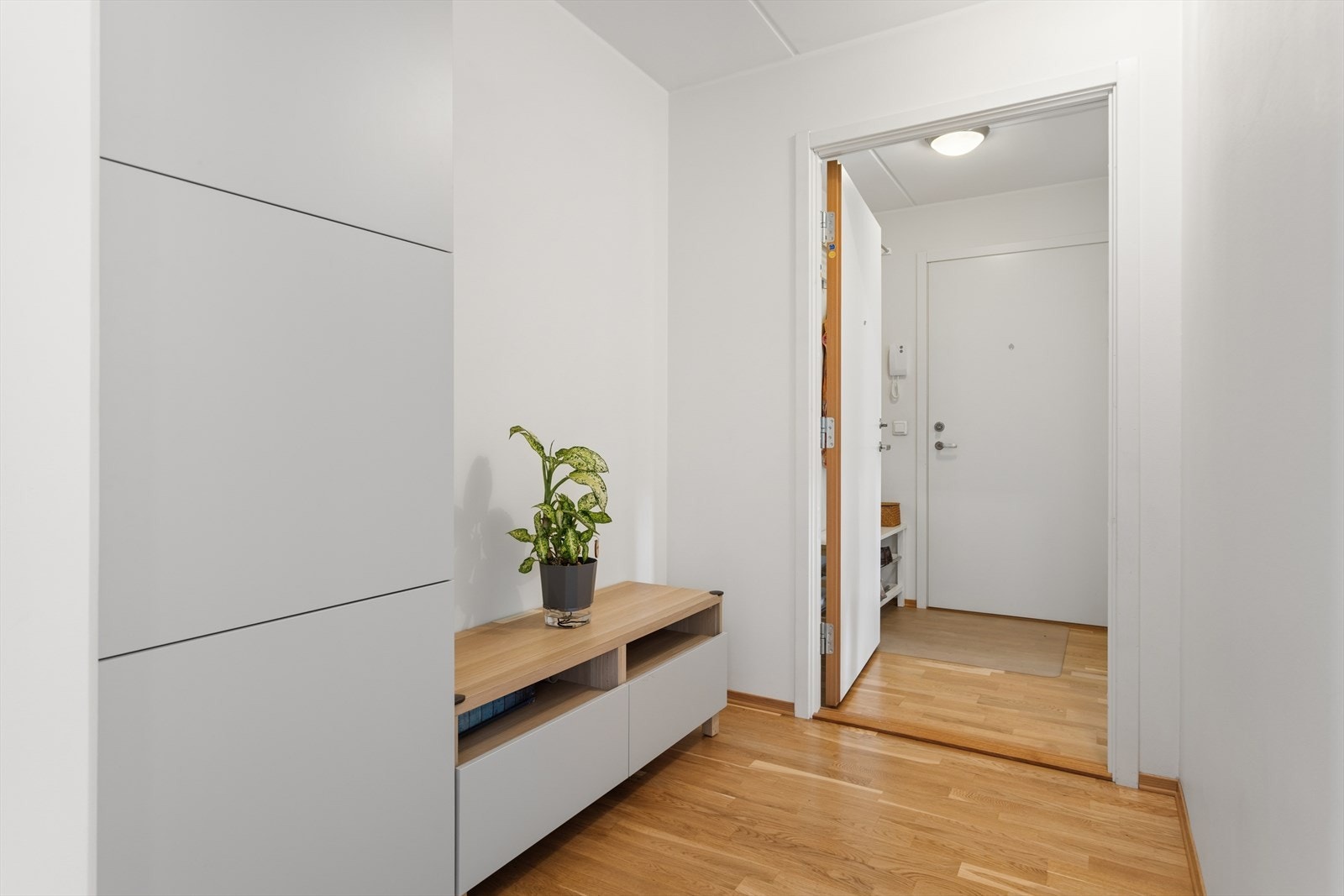 Adkomst fra felles gang til boligens hoveddel. Gode oppbevaringsmuligheter i garderobeskap med glatte, folierte fronter. Galleribilde