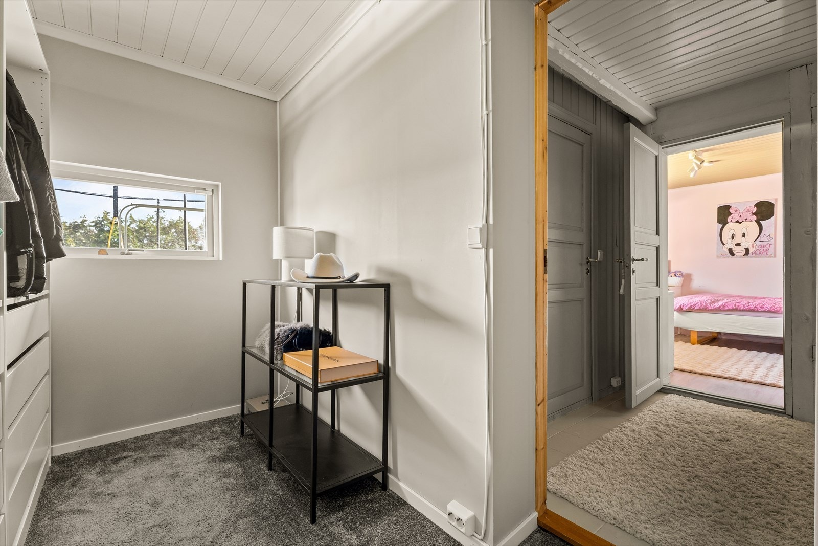 Gjennomgangsrom i kjelleren med teppegulv og gode garderobemuligheter. Galleribilde