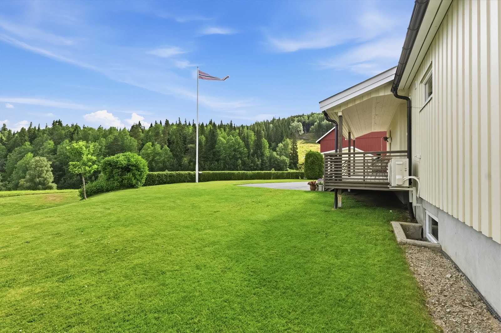 Åpent og innbydende uteområde med velstelt plen. Galleribilde