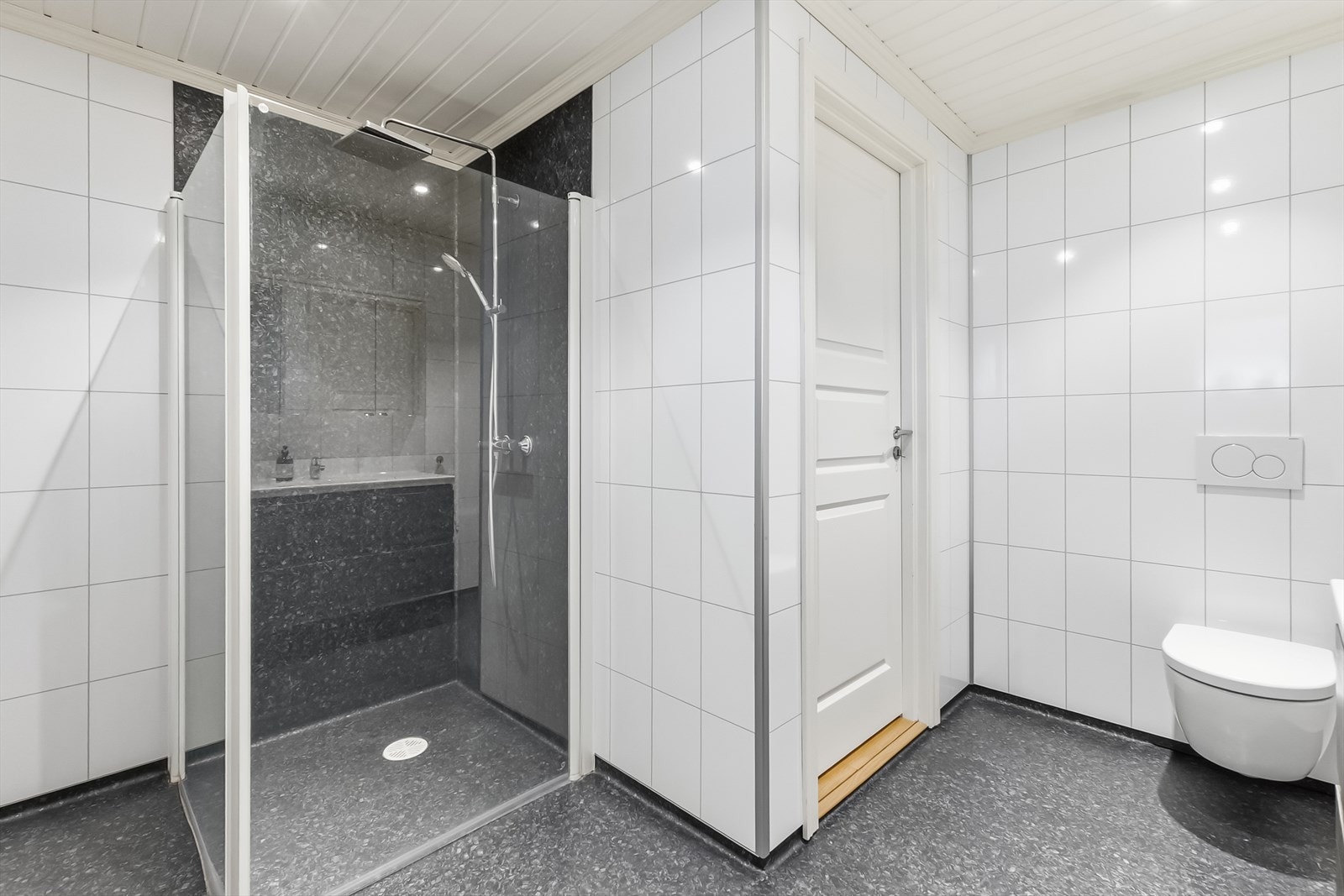Takdusj, vegghengt toalett og downlights gjør badet lyst og moderne. Galleribilde