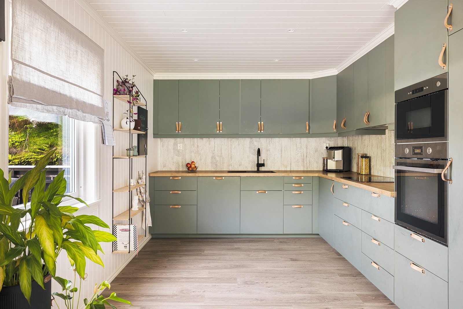Stilren kjøkkeninnredning i moderne fargevalg levert av IKEA. Kjøkkeninnredningen består av glatte fronter med skinnhåndtak og benkeplate i laminat. Galleribilde