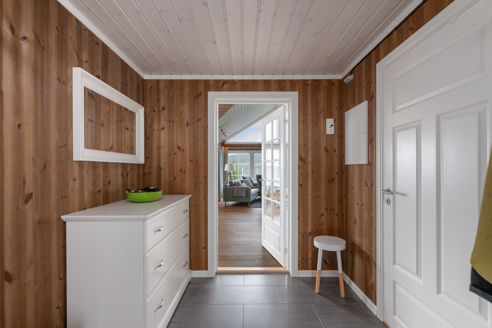 Fra entreen leder en dør med glassfelt inn til stuen. Galleribilde