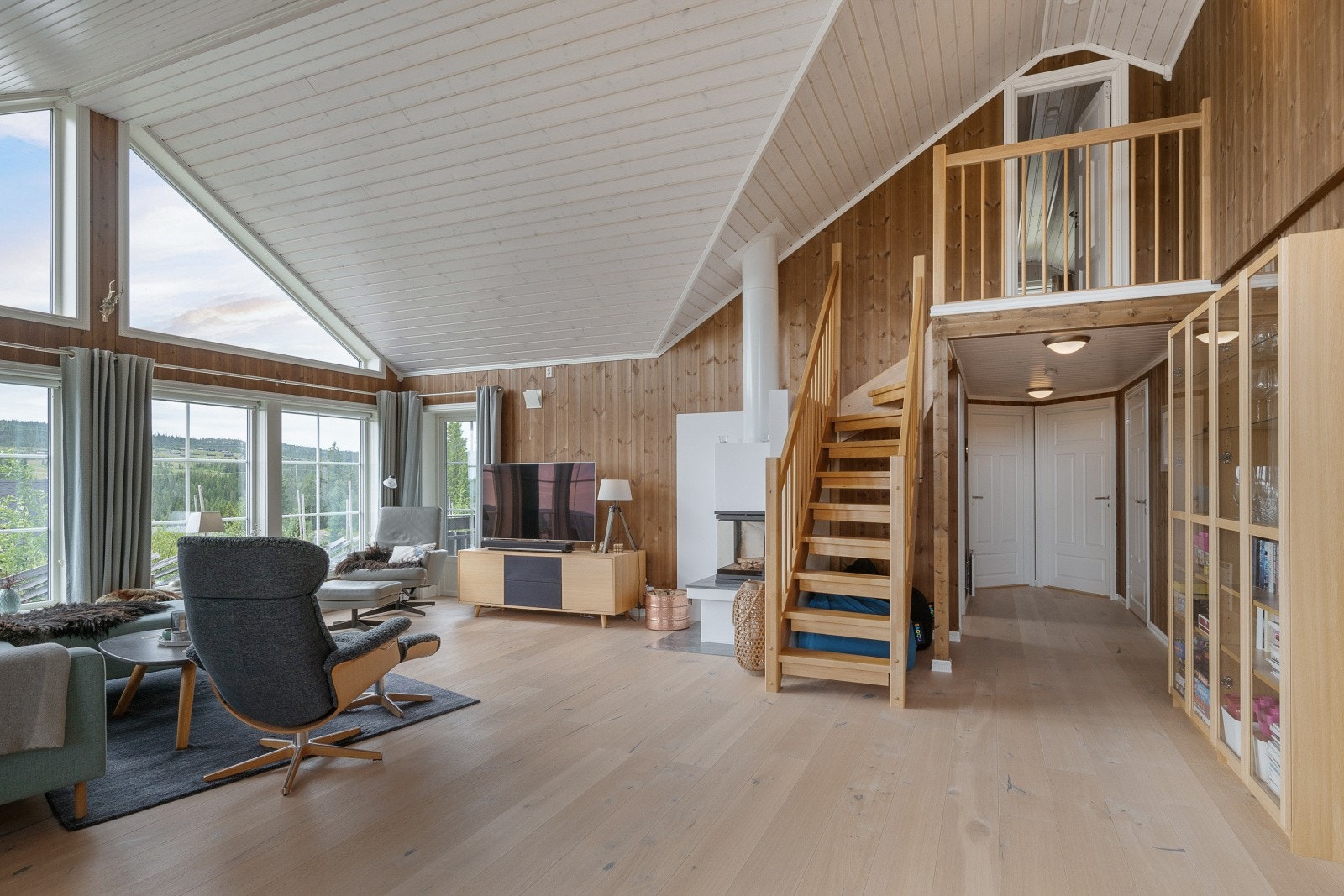 Trapperommet fører opp til hemsen, som er innredet med sengeplasser og TV. Galleribilde