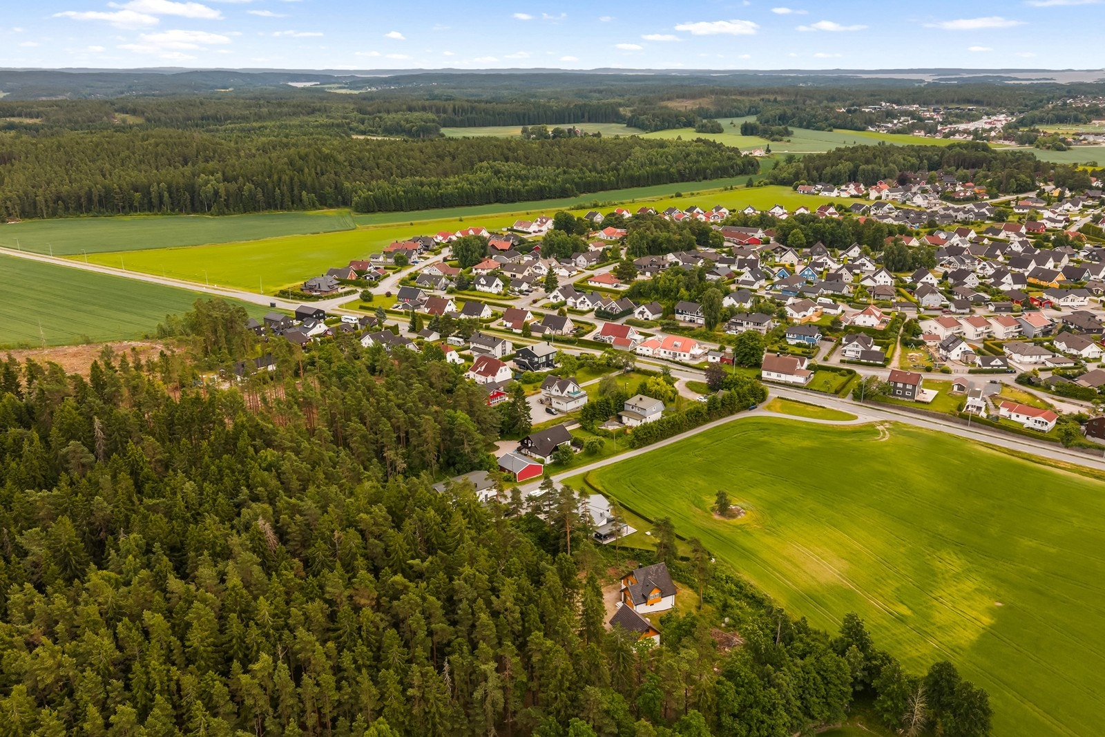 Beliggenheten byr på en kombinasjon av boligbebyggelse, landbruk og grønne omgivelser. Galleribilde
