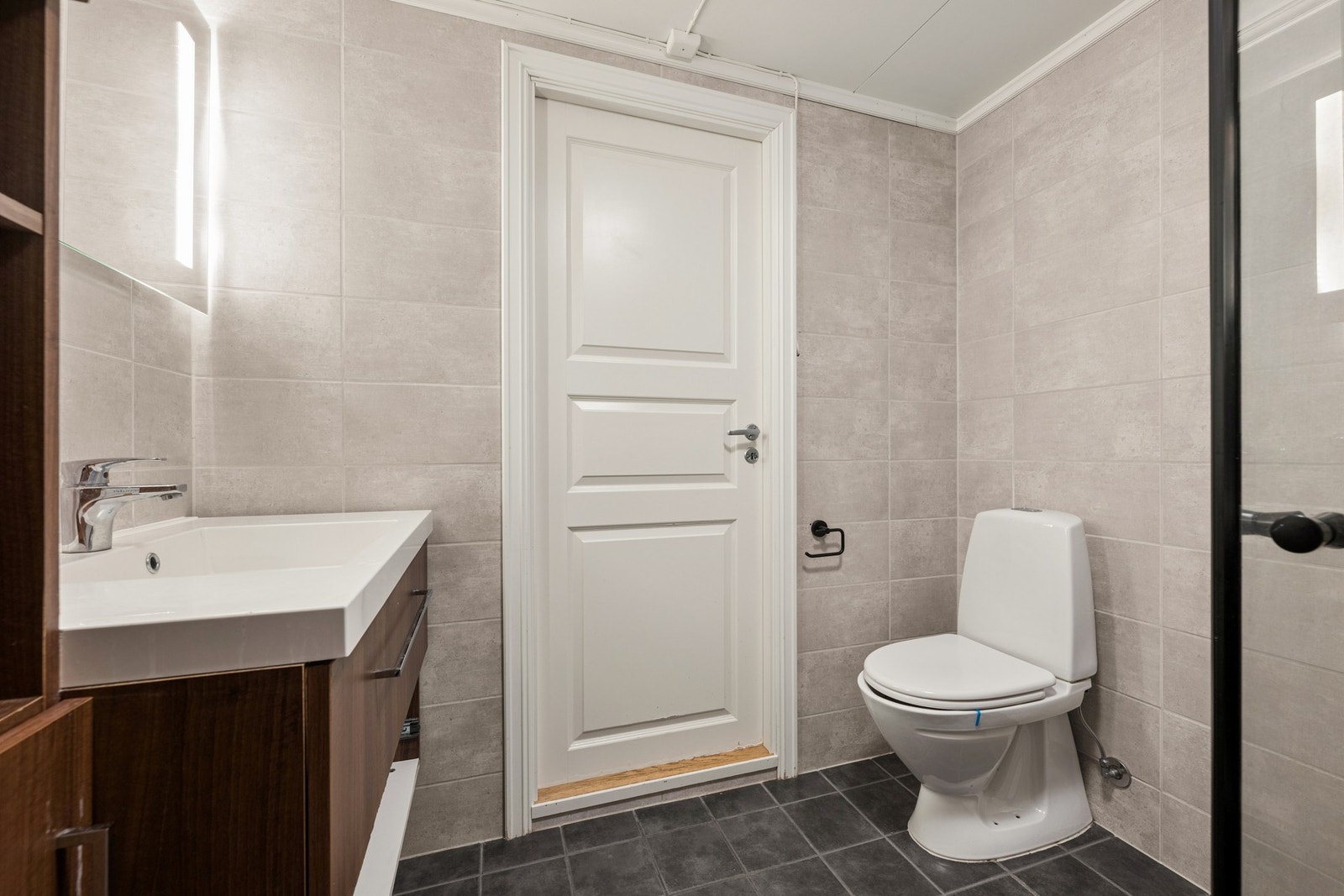 Badet er innredet med servantskap, toalett og dusj. Galleribilde