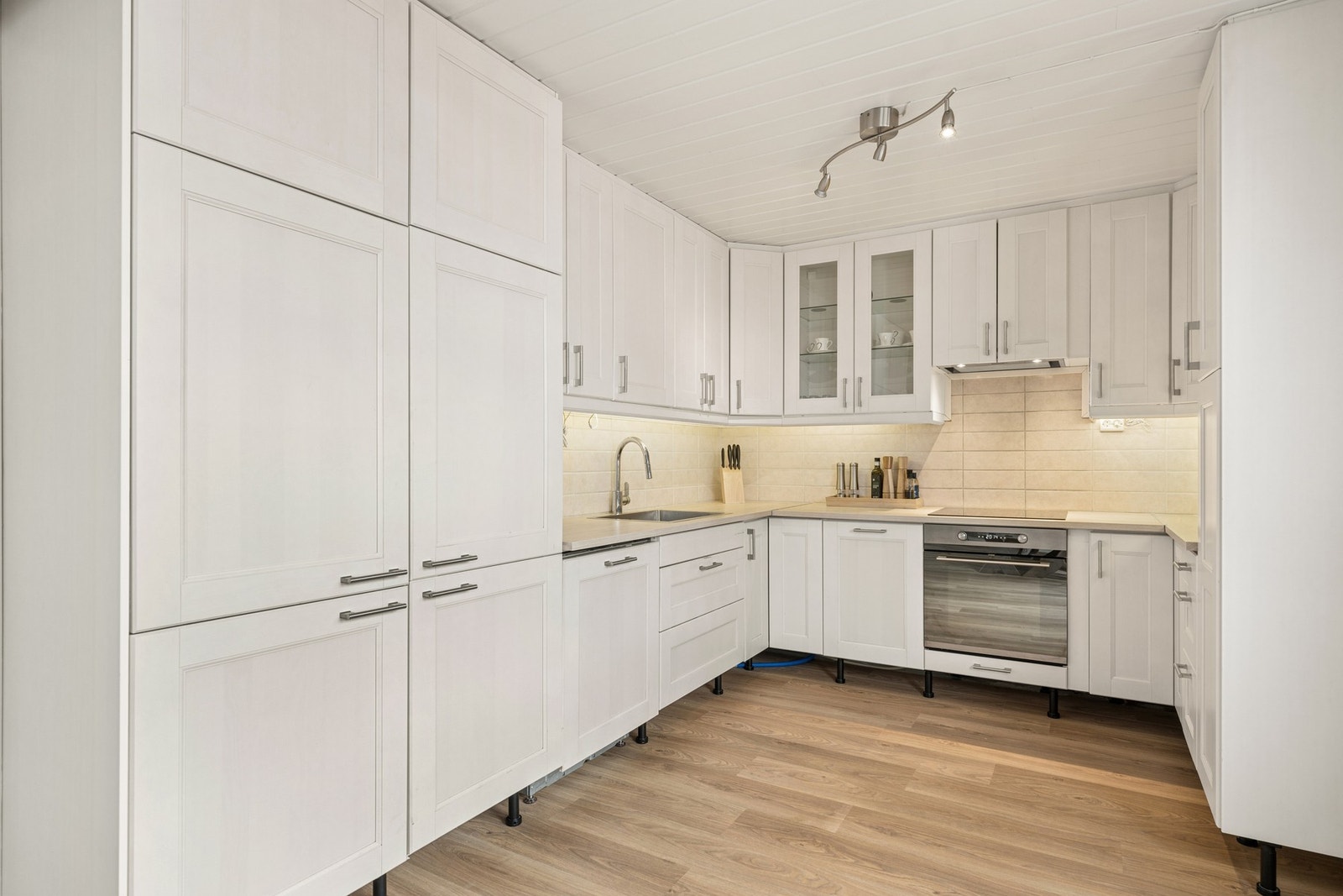 Et stilrent og tidløst IKEA kjøkken med integrerte hvitevarer. Galleribilde
