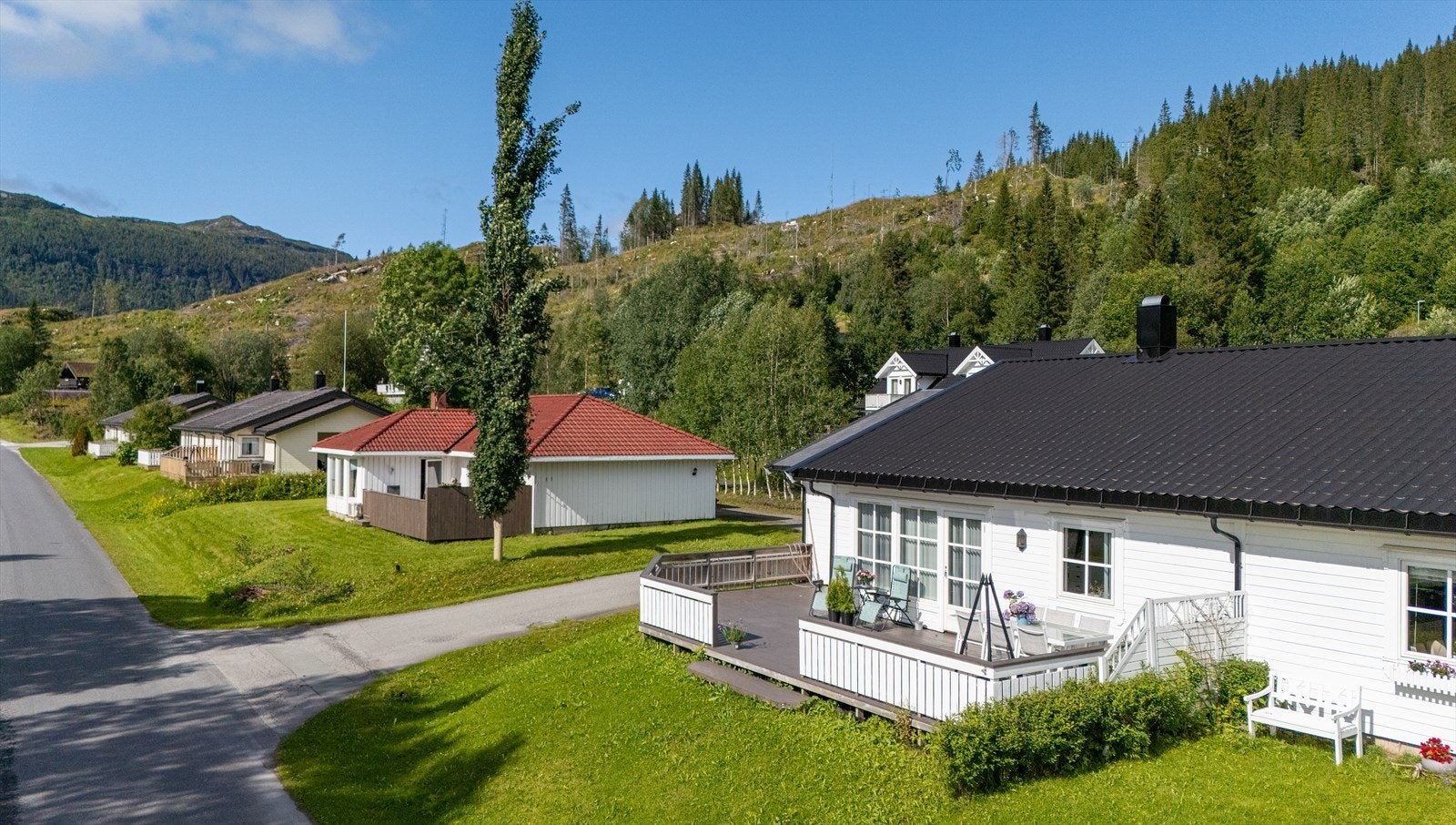 Utgang til stor terrasse på hele 46 m2 hvor solen kan nytes. Tilbygget carport med sportsbod i bakkant. Galleribilde