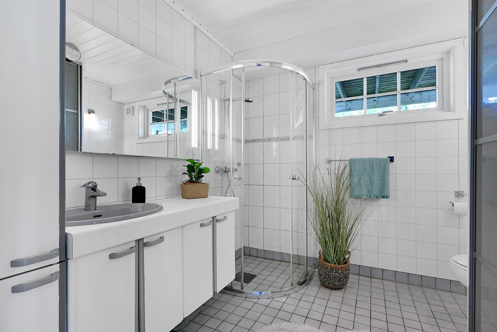 Badet i 1.etg. har flislagt gulv og vegger med en kombinasjon av fliser og baderomsplater. Galleribilde