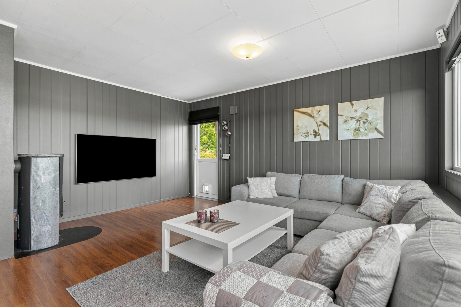 Stuen har en lun og hyggelig atmosfære, med vedovn og god plass til en romslig sofagruppe. Galleribilde
