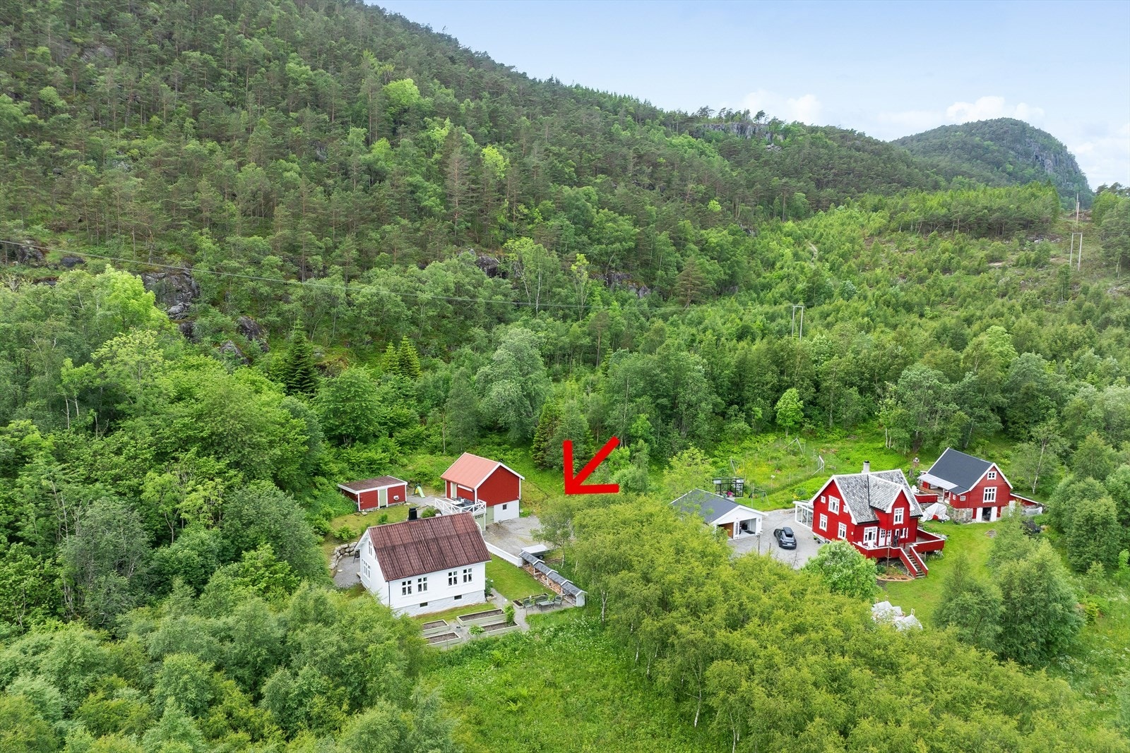 Eiendommen fremstår som et koselig og helhetlig tun med bolighus, uthus og hageområder pent bundet sammen. Galleribilde