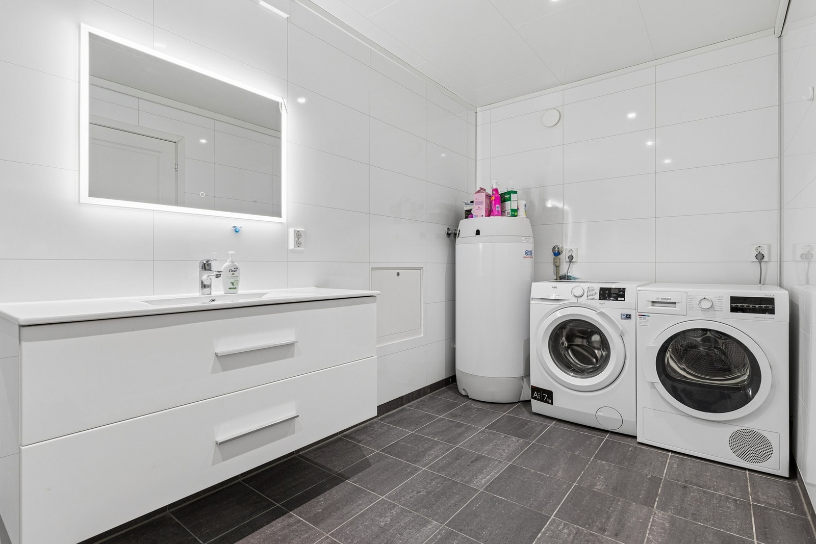 Badet har flislagt gulv med elektriske varmekabler og opplegg for vaskemaskin. Galleribilde