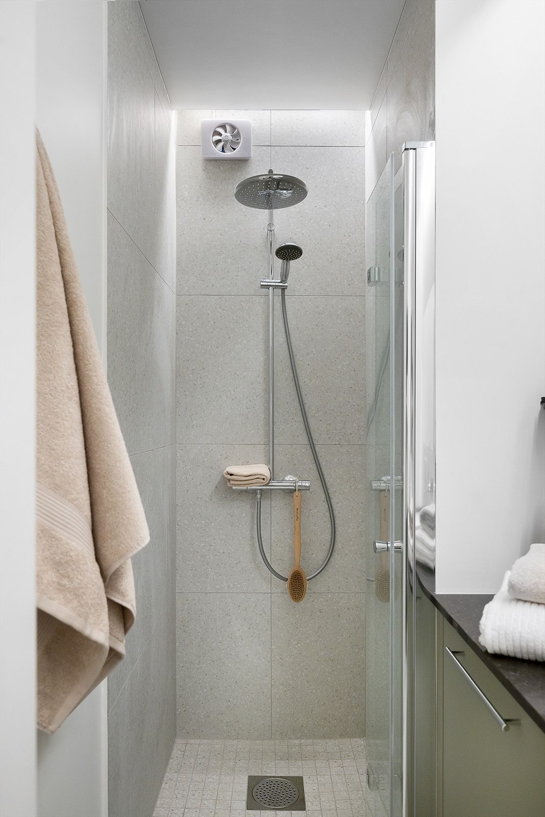 Gulv og dusjsone er flislagt, mens øvrige veggflater er malt, noe som gir badet et moderne og lett uttrykk. Det er mekanisk avtrekksvifte i vegg, varmekabler i gulv og opplegg for vaskemaskin. Galleribilde