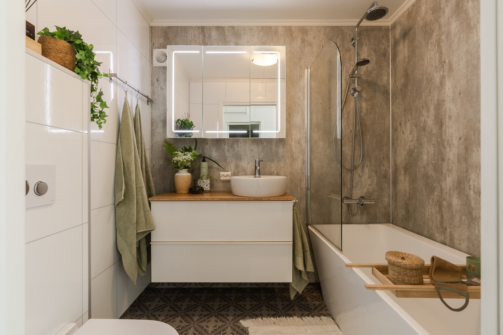 Badet er innredet med toalett, servant i baderomsinnredning og badekar med dusj. Galleribilde
